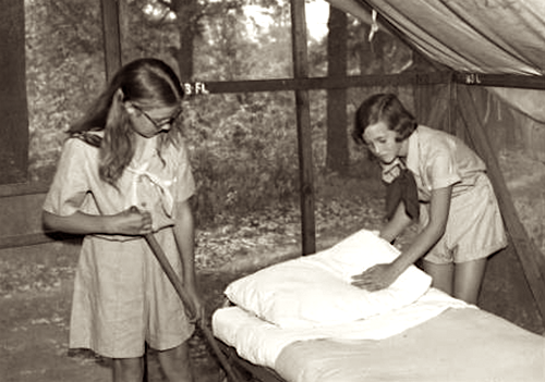 Girls cleaning a platform tent in 1940
