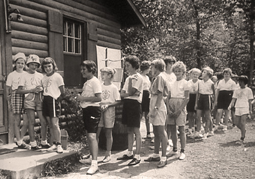 Girls lined up outside the first troop cabin built for the camp in 1949